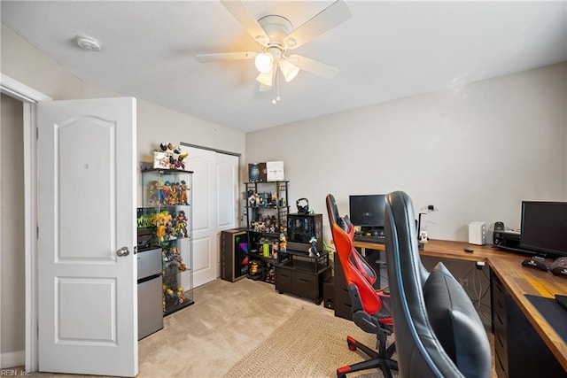 carpeted office space with ceiling fan