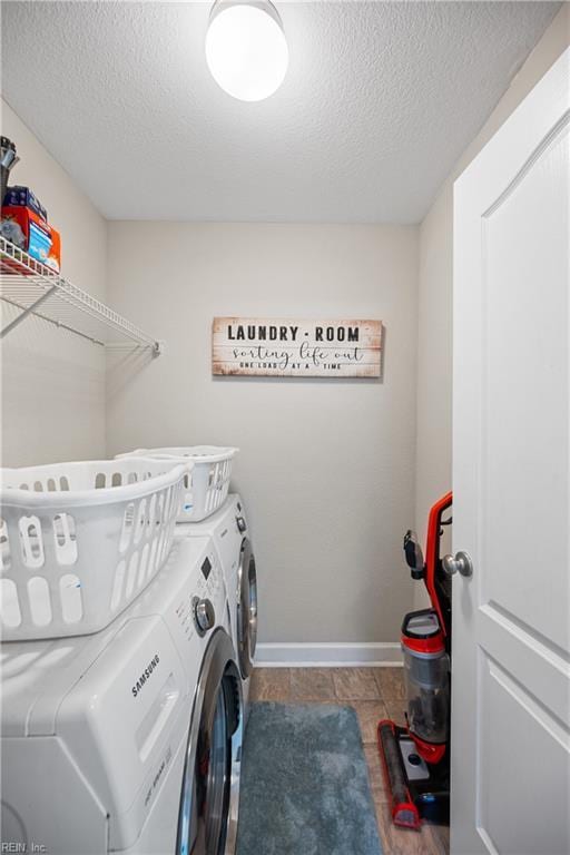 laundry room featuring tile patterned flooring, washing machine and dryer, and a textured ceiling