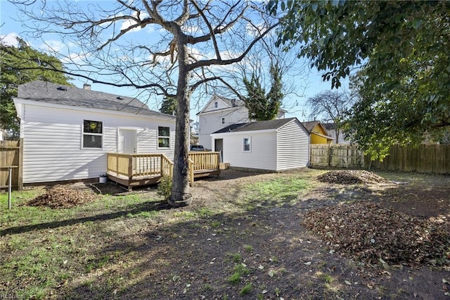 rear view of property with an outdoor structure and a deck