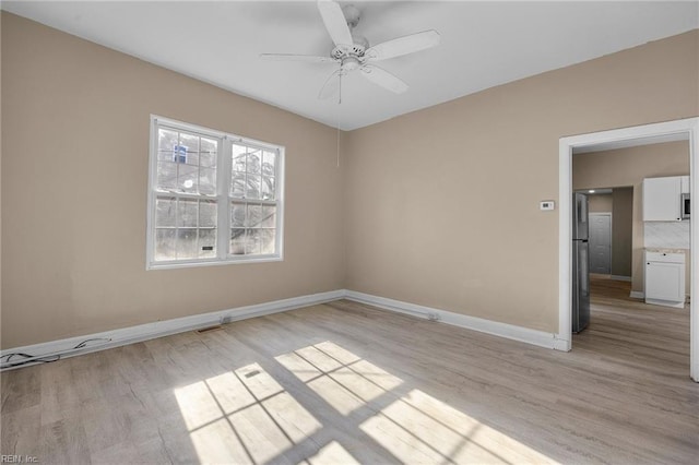 empty room with ceiling fan and light wood-type flooring