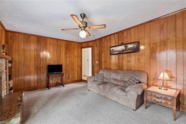 living room featuring crown molding, light colored carpet, ceiling fan, and wood walls