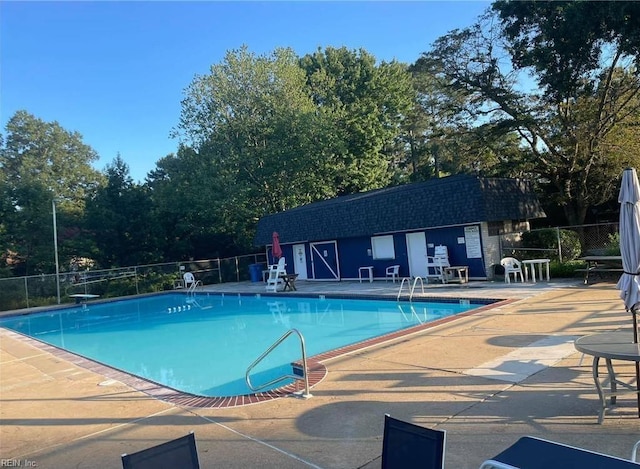 view of pool featuring a diving board and a patio area