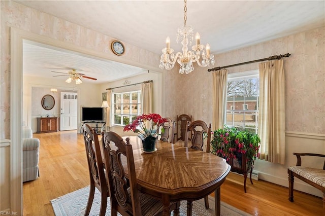 dining area featuring ceiling fan with notable chandelier and light hardwood / wood-style floors