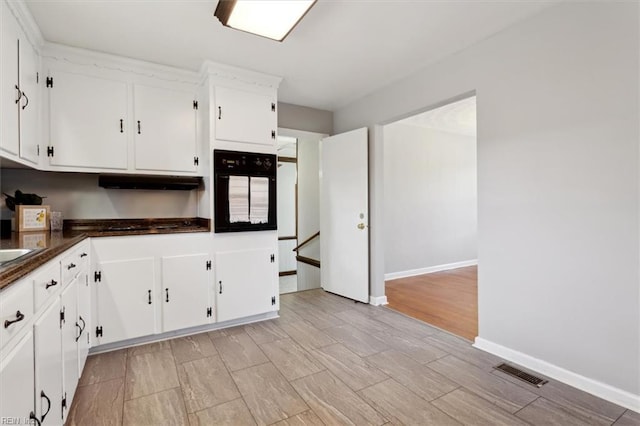 kitchen featuring white cabinetry and black oven