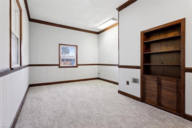 empty room featuring crown molding and light colored carpet