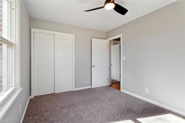 unfurnished bedroom with light colored carpet, ceiling fan, and a closet