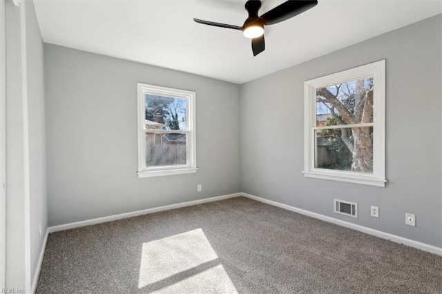 carpeted empty room featuring a wealth of natural light and ceiling fan