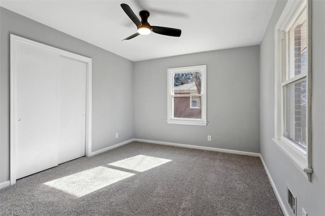 unfurnished bedroom with carpet, ceiling fan, and a closet