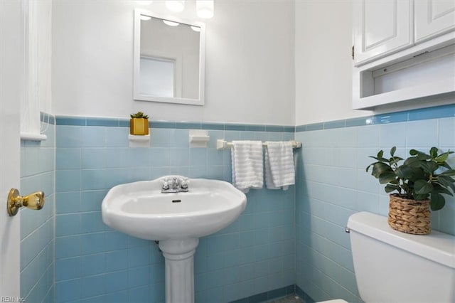 bathroom with tile walls, sink, and toilet