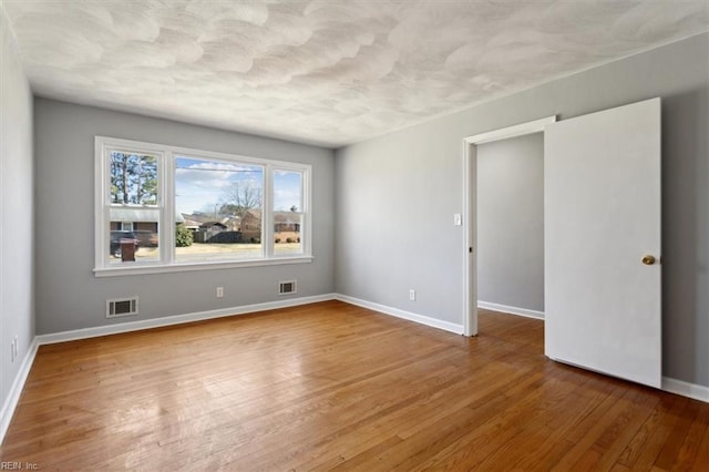 empty room with hardwood / wood-style floors