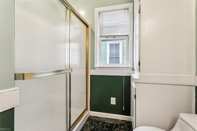 bathroom featuring toilet and walk in shower