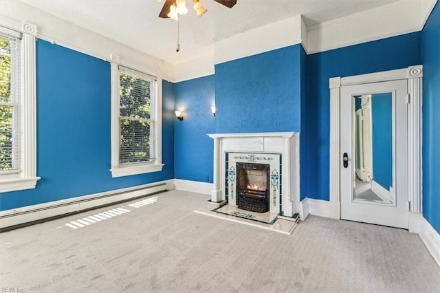 unfurnished living room with ceiling fan, a baseboard radiator, carpet flooring, and a fireplace