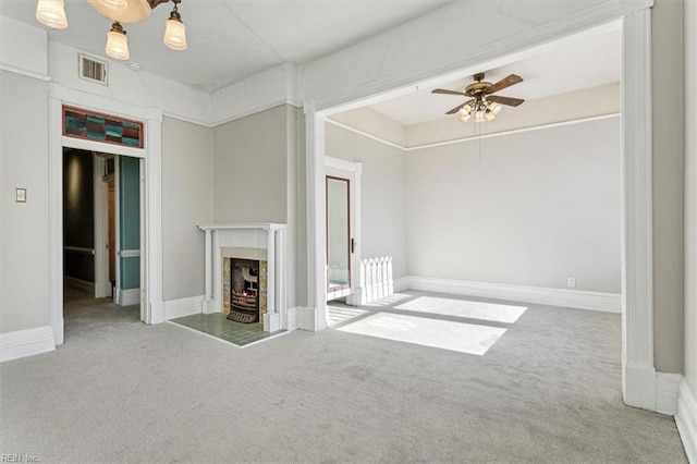 unfurnished living room featuring a premium fireplace, carpet flooring, and ceiling fan