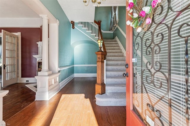 foyer featuring decorative columns and dark wood-type flooring