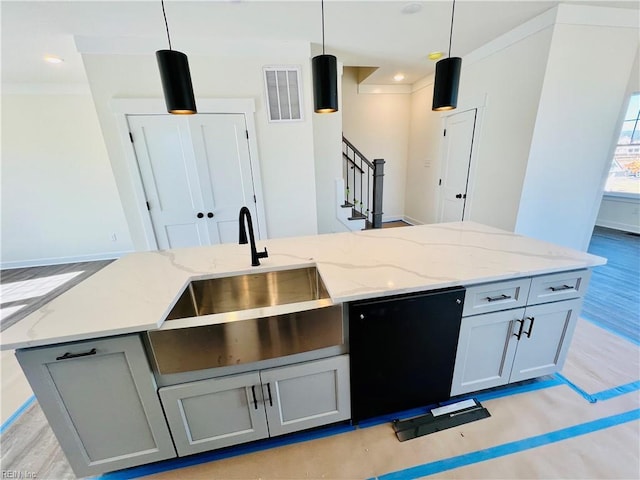 kitchen with decorative light fixtures, dishwasher, and an island with sink