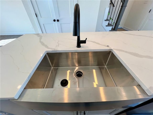 details featuring light stone countertops, sink, and white cabinets