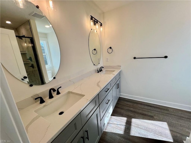 bathroom featuring vanity, wood-type flooring, and walk in shower