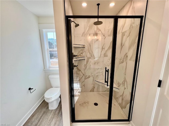 bathroom featuring wood-type flooring, an enclosed shower, and toilet