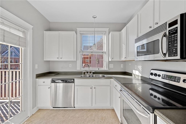 kitchen with white cabinetry, sink, decorative light fixtures, and appliances with stainless steel finishes