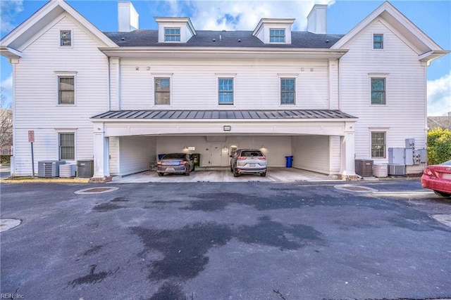 back of property with central AC and a garage