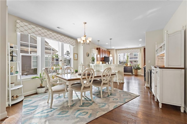 dining area with dark hardwood / wood-style flooring and a chandelier