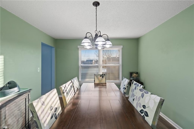 dining space featuring a notable chandelier and a textured ceiling