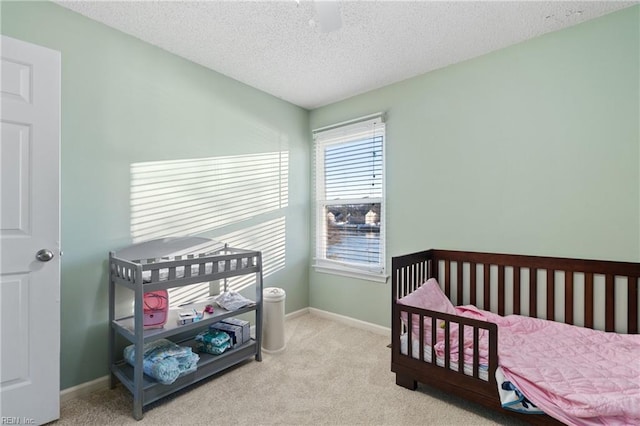 bedroom featuring light colored carpet and a textured ceiling