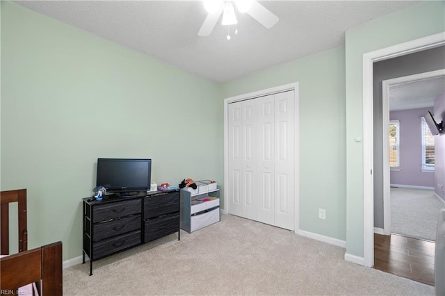 carpeted bedroom featuring ceiling fan and a closet