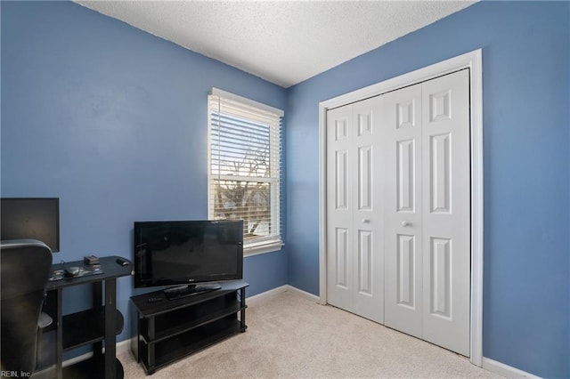 carpeted home office with a textured ceiling