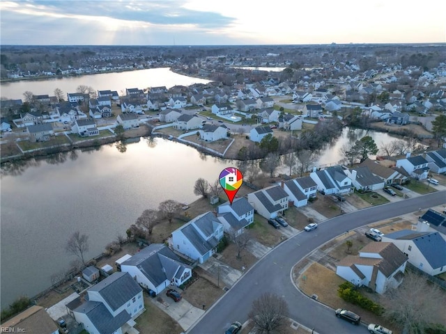 aerial view at dusk featuring a water view