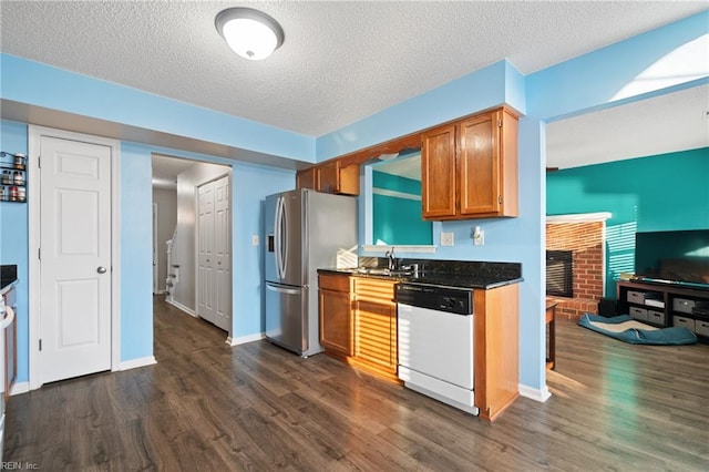 kitchen with stainless steel fridge, white dishwasher, dark wood-type flooring, and a textured ceiling