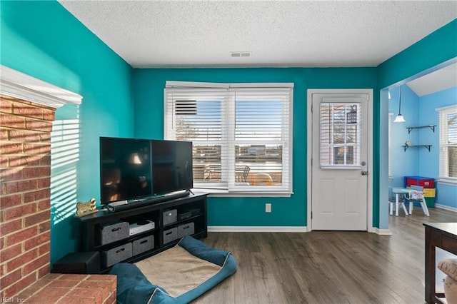 living room featuring dark wood-type flooring and a textured ceiling