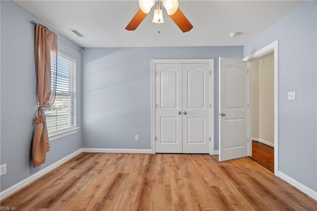 unfurnished bedroom with light hardwood / wood-style flooring, a closet, and ceiling fan