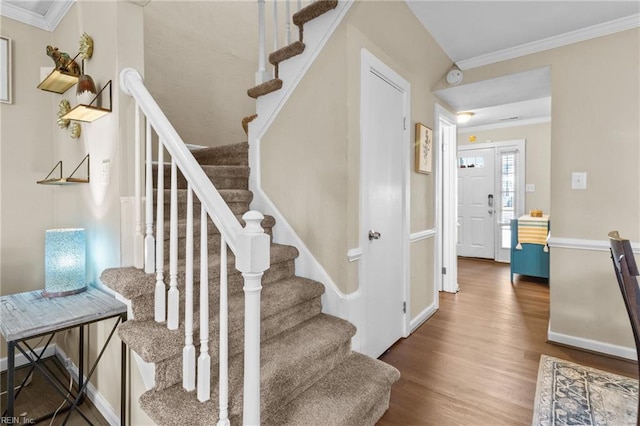 stairway featuring hardwood / wood-style floors and crown molding