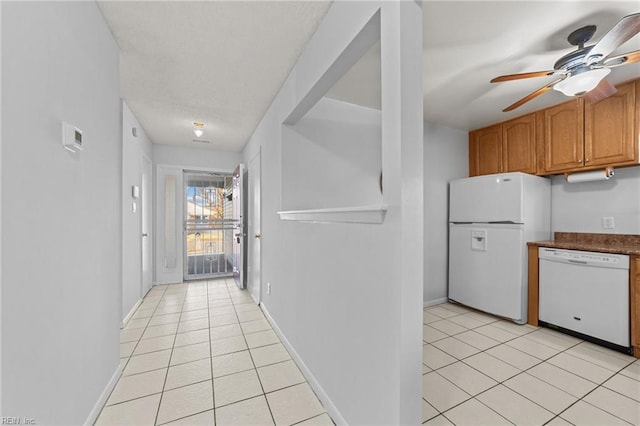 kitchen featuring light tile patterned floors, white appliances, and ceiling fan