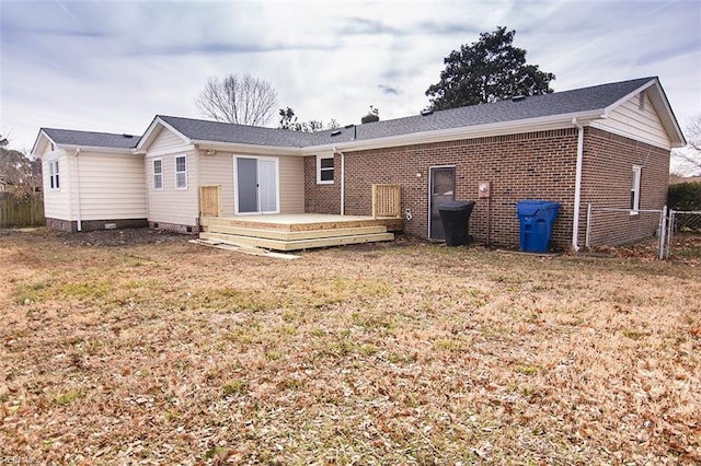 rear view of property featuring a deck and a lawn