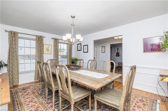 dining space featuring an inviting chandelier, hardwood / wood-style floors, and crown molding