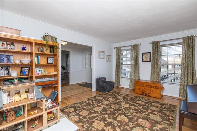 sitting room with wood-type flooring and ornamental molding