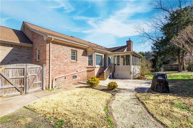 back of house featuring a sunroom and a patio area