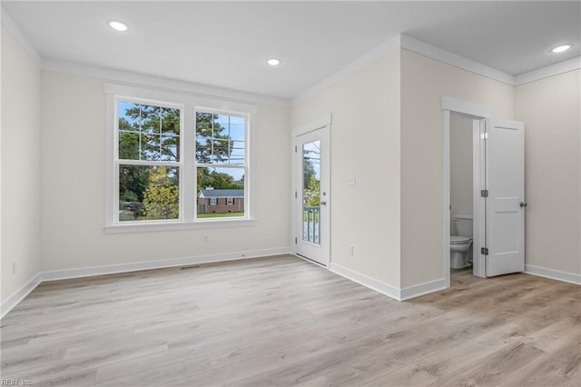 unfurnished room featuring crown molding and light wood-type flooring