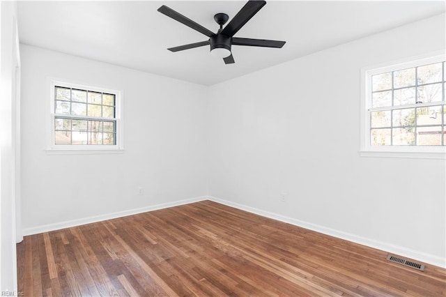 empty room with hardwood / wood-style floors, plenty of natural light, and ceiling fan