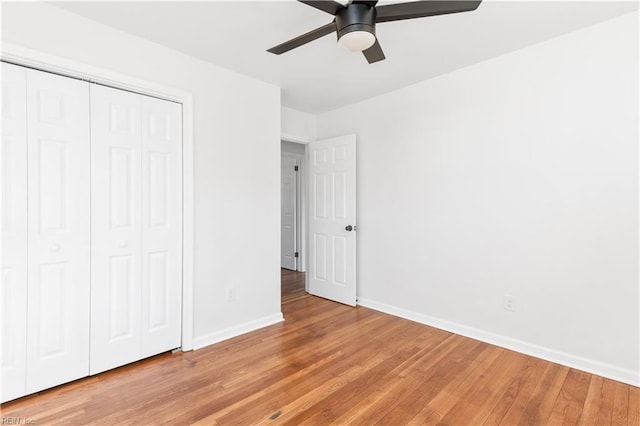 unfurnished bedroom featuring wood-type flooring, a closet, and ceiling fan