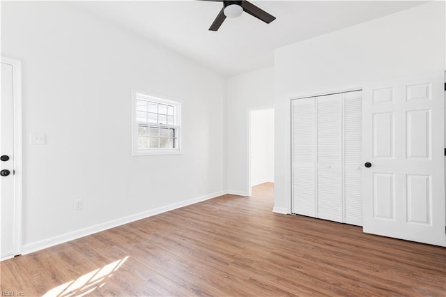 unfurnished bedroom with hardwood / wood-style flooring, ceiling fan, and a closet