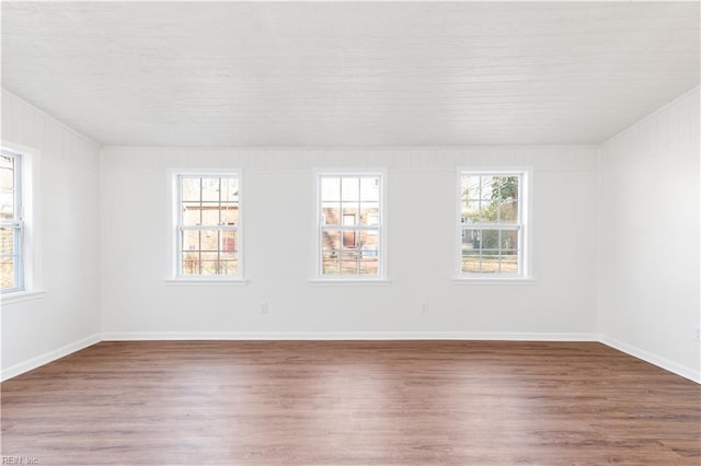 unfurnished room with a wealth of natural light and dark wood-type flooring