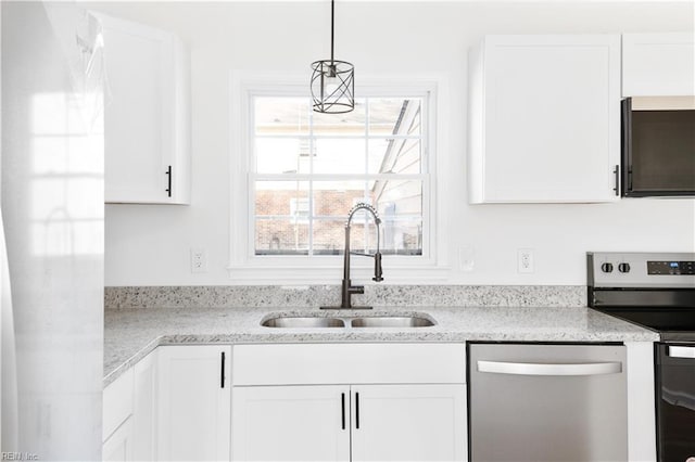 kitchen with sink, white cabinetry, decorative light fixtures, stainless steel appliances, and light stone countertops