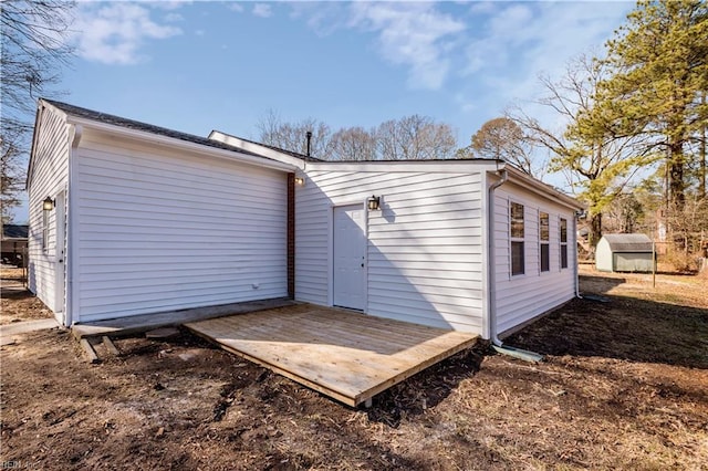 back of house featuring a shed and a wooden deck