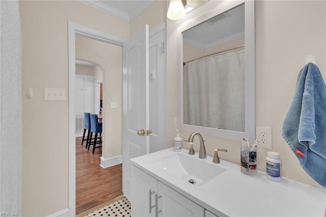 bathroom with vanity, wood-type flooring, and ornamental molding