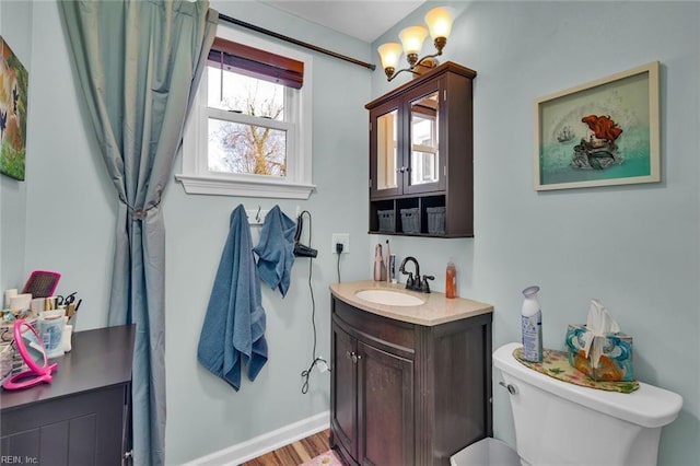 bathroom featuring vanity, wood-type flooring, and toilet