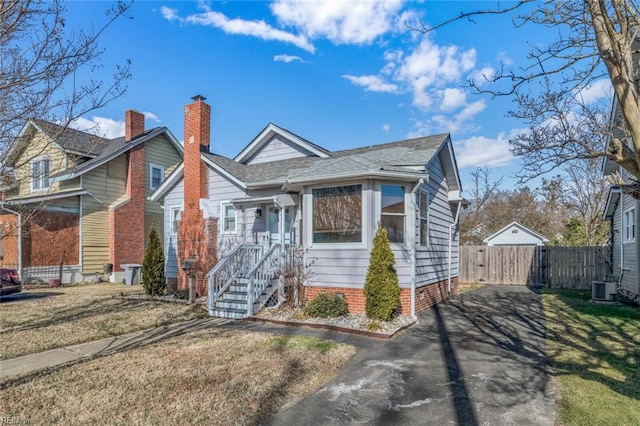 bungalow-style house with cooling unit and a front yard