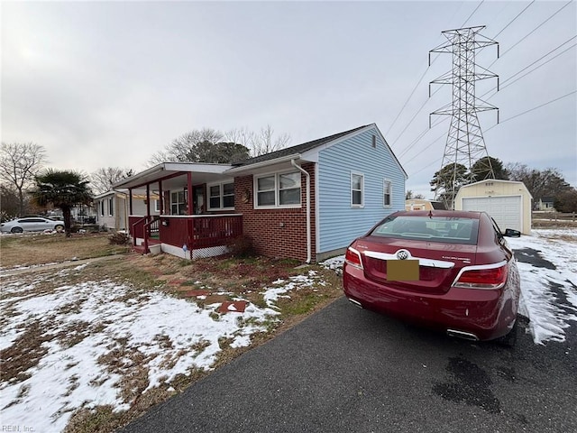 view of front of home featuring an outbuilding, a garage, and a porch